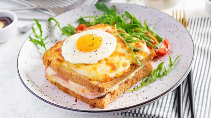 A serving of croque madame casserole on a plate with a side salad