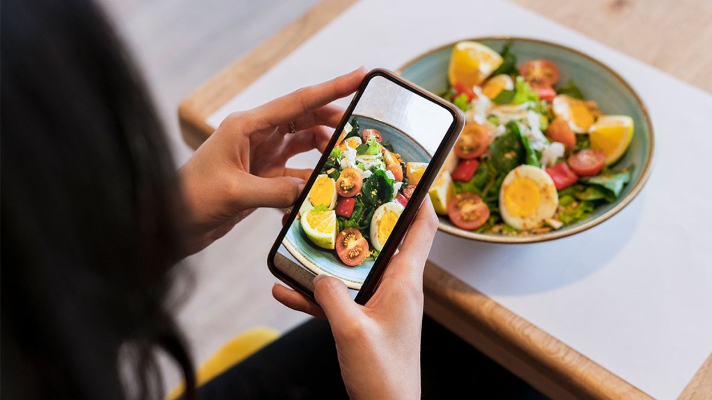 woman taking a photo of her food: mindful eating for weight loss