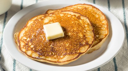 Pancakes topped with butter as part of a guide on how to reheat them