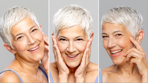 mature woman with gray hair doing face yoga