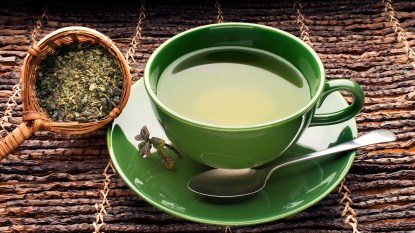 Cup of freshly brewed green tea, which can help with bloat