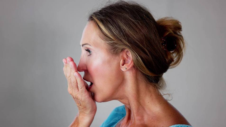Woman checking her breath; how to get rid of garlic breath