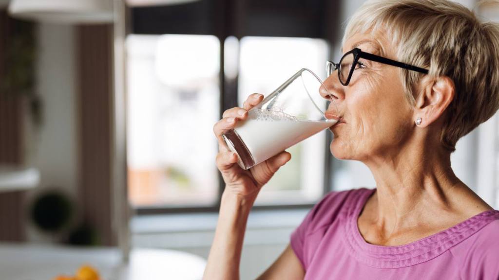 Woman drinking glass of milk ; How to get rid of garlic breath