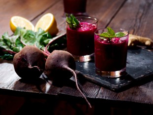 red beets and beetroot juice in glasses on a wooden block