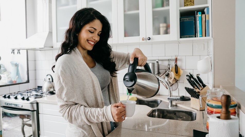 Woman pouring water from an electric kettle