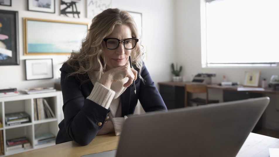 women wearing glasses stares at a computer screen while concentrating