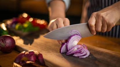 how to cut onions without crying: female chef Cutting onions