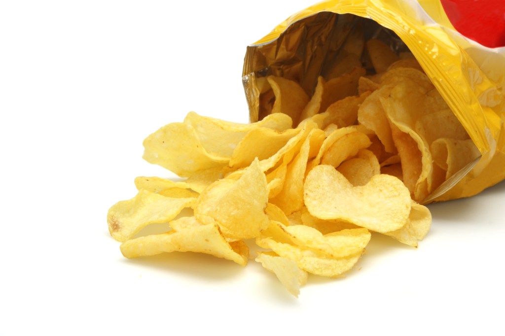 Bag of golden chips isolated on a white background.