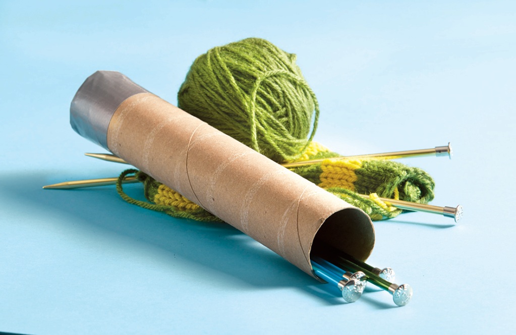 knitting needles inside a cardboard tube taped closed at one end