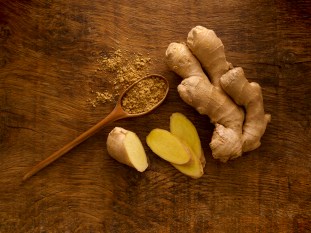 sliced ginger root and ginger powder on table