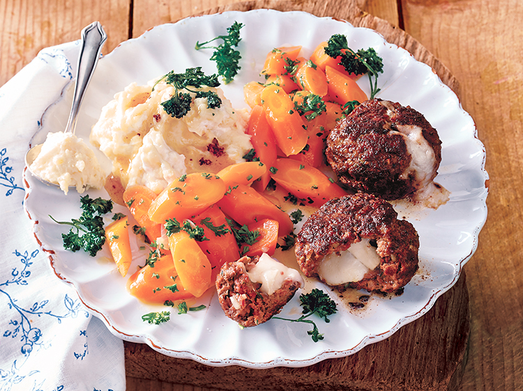 stuffed meatballs with carrots and mashed potatoes on a white plate