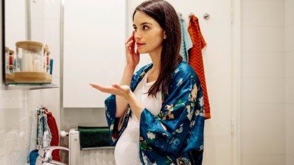 Pregnant woman putting on makeup