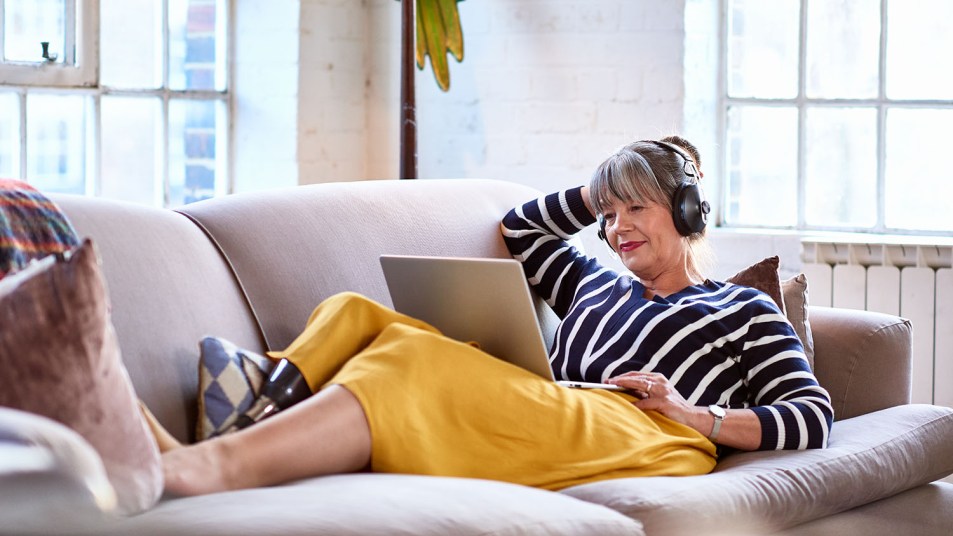 woman listening to headphones looking at computer