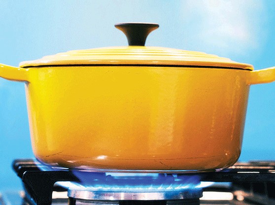 yellow ceramic pot sitting on a gas burner