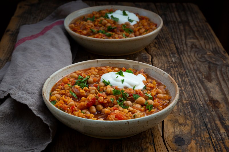 two bowls of red lentil soup with chickpeas
