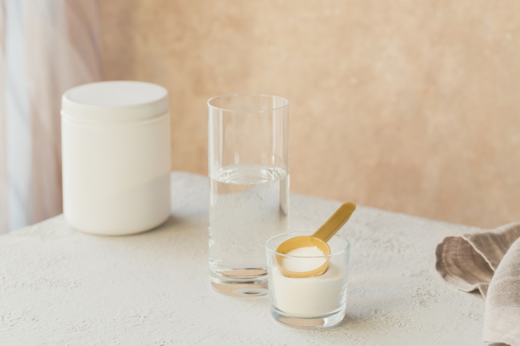 Collagen powder next to glass of water.