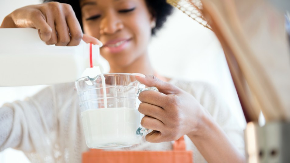 Woman pouring milk into measuring cup