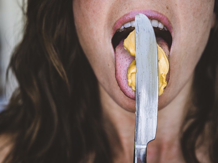 Cropped Image Of Woman Licking Peanut Butter