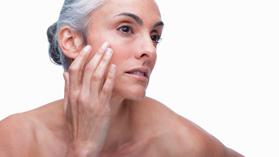 woman putting night cream on her face