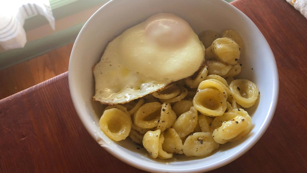Finished pasta dish with an egg on it