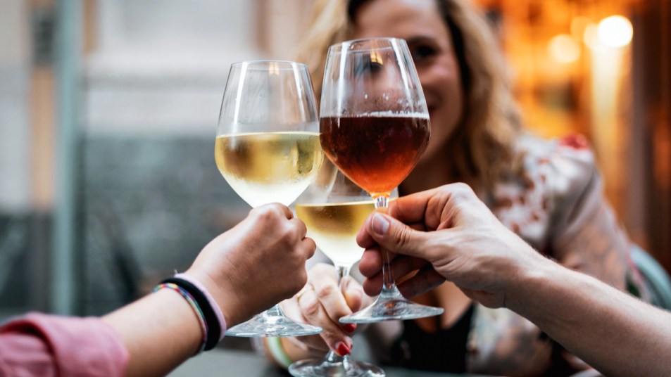 Group of people cheers-ing glasses of wine