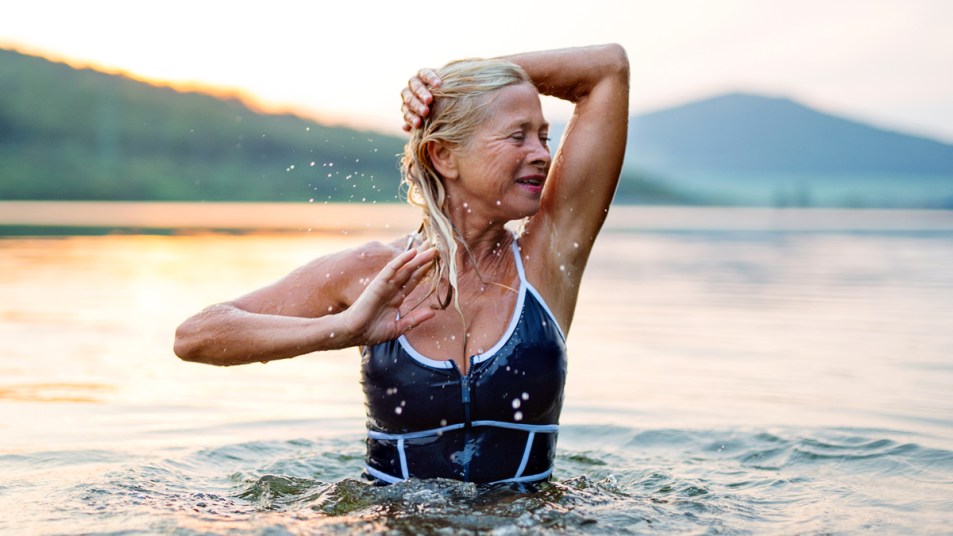 Woman touching her hair swimming in a lake