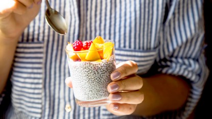 Woman's hands holding cup of yogurt with chia seeds
