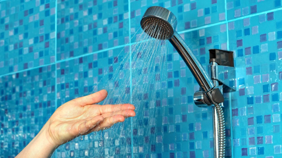 Hand checking shower water temperature