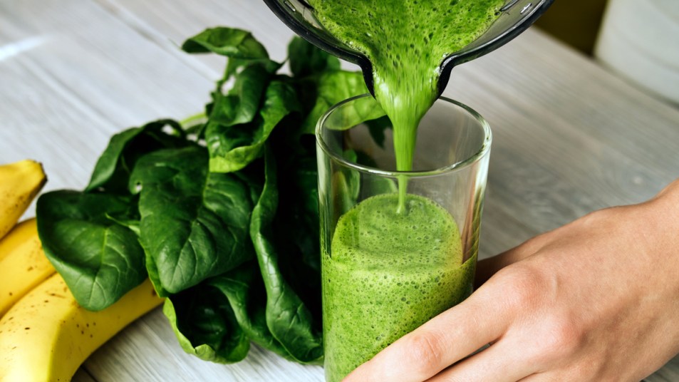 Woman pouring green smoothie