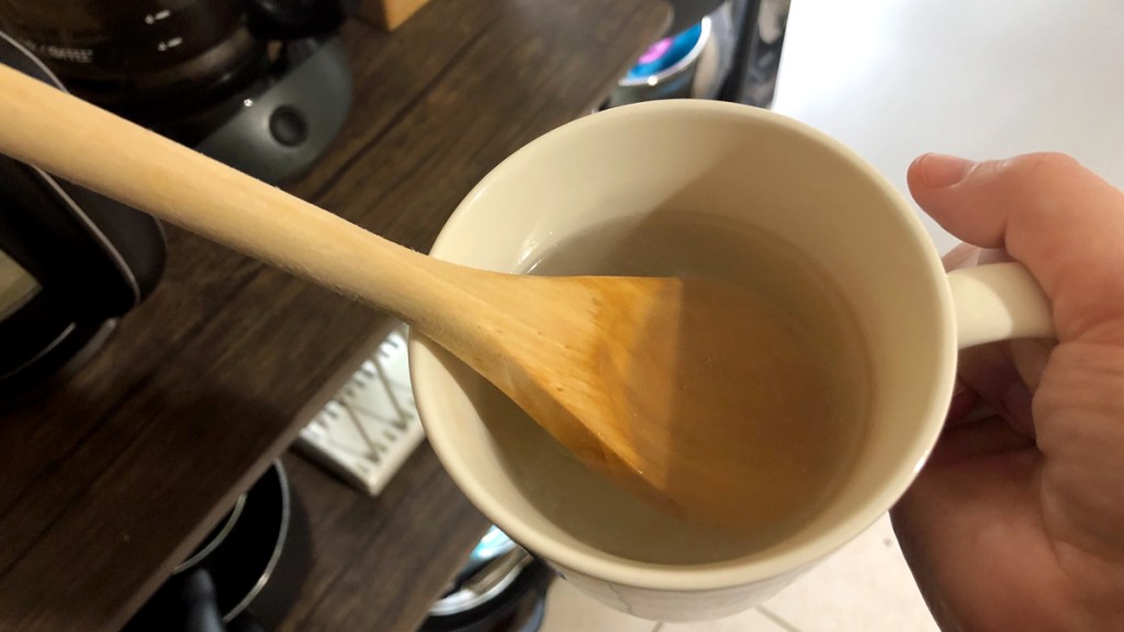 Wooden spoon in a mug of boiling water