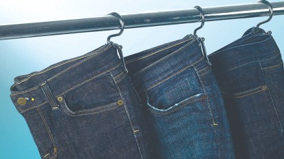 Hang jeans on shower curtain hooks for a closet organizer DIY
