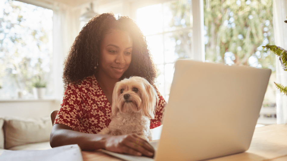 woman with dog typing on laptop