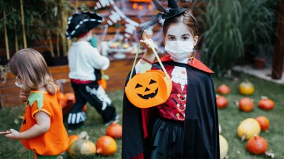 Kids in Halloween costumes with COVID-19 face masks