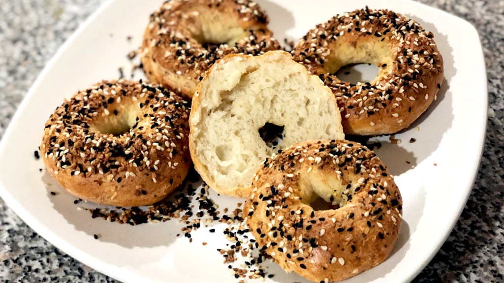 Four everything bagels on a plate