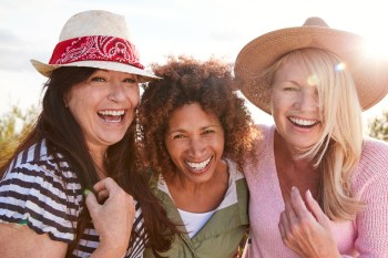 three mature female friends smiling