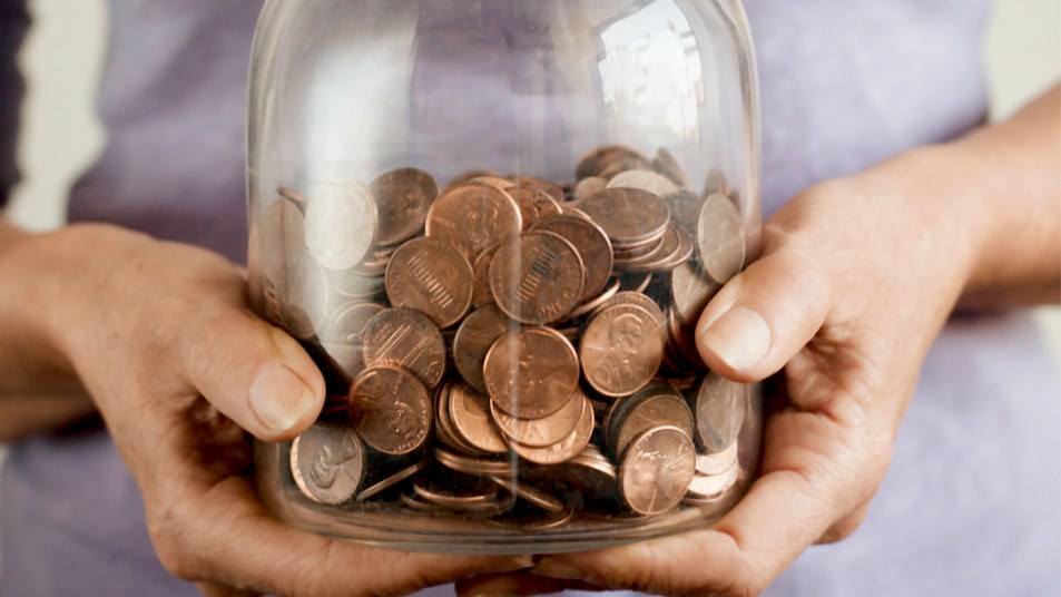 Hands holding jar of pennies
