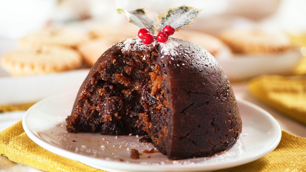 A garnished figgy pudding with a slice removed