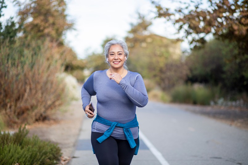 A mature woman jogging on a trail