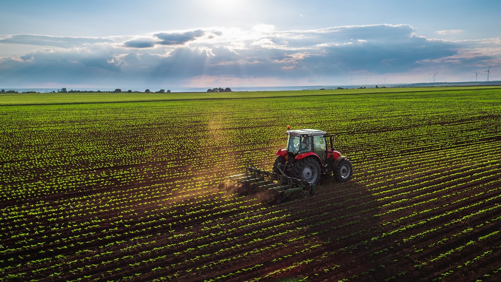 Tractor plowing a field in spring to illustrate how factory farming has depleted foods of magnesium