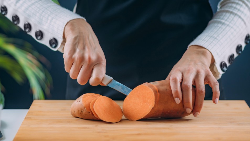 Woman's hands slicing sweet potato