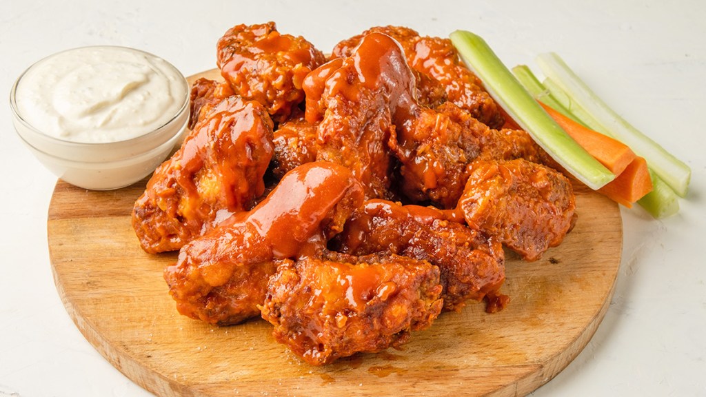 A platter of Buffalo wings as part of a guide on reheating them in the oven