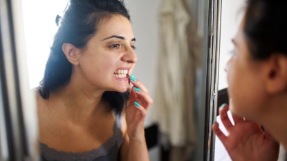 Woman looking at her teeth in a mirror