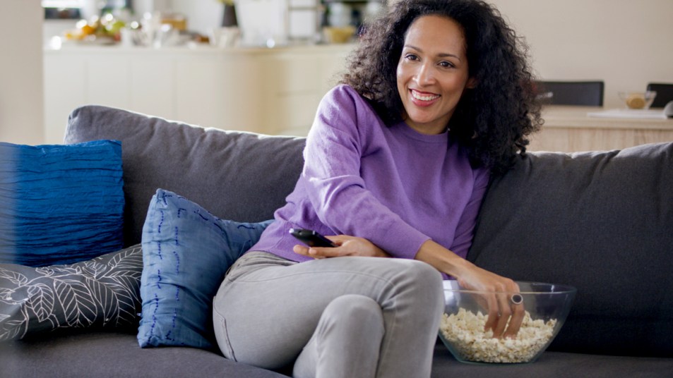 Woman reaching for popcorn on the couch