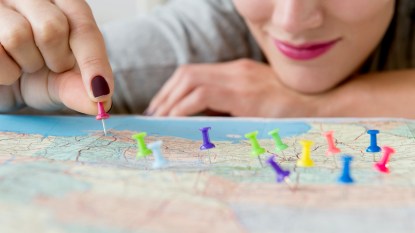 Woman putting colorful pins in a map