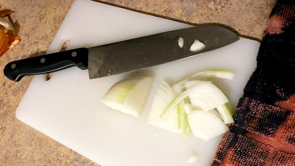 Knife and onion on cutting board