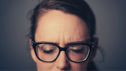 woman wearing glasses and closing her eyes