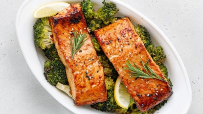 Roasted salmon fillets over broccoli as part of a guide on how to reheat the fish