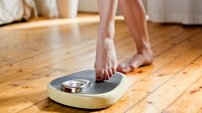 Woman's feet stepping on scale