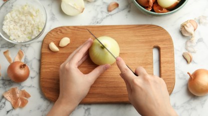 A woman cutting onions