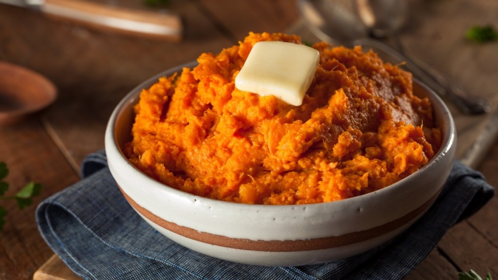 A bowl of mashed sweet potato with a pat of butter, which can help ease menopause symptoms